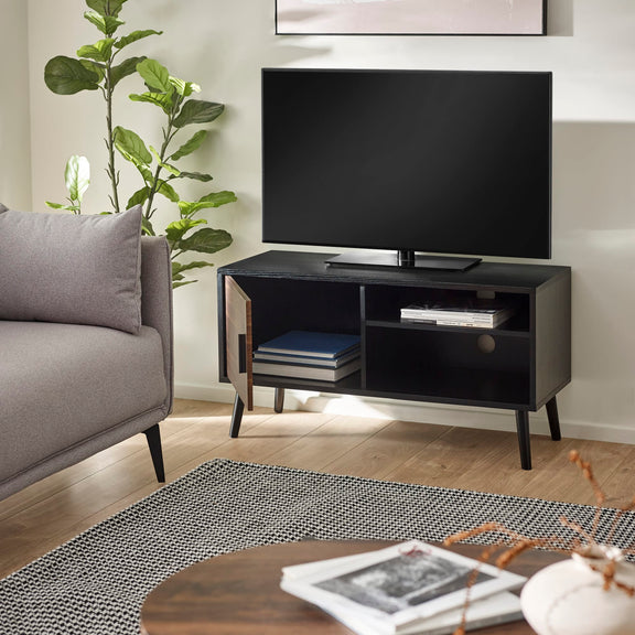 Modern living room with a black TV stand, gray sofa, and decorative items.