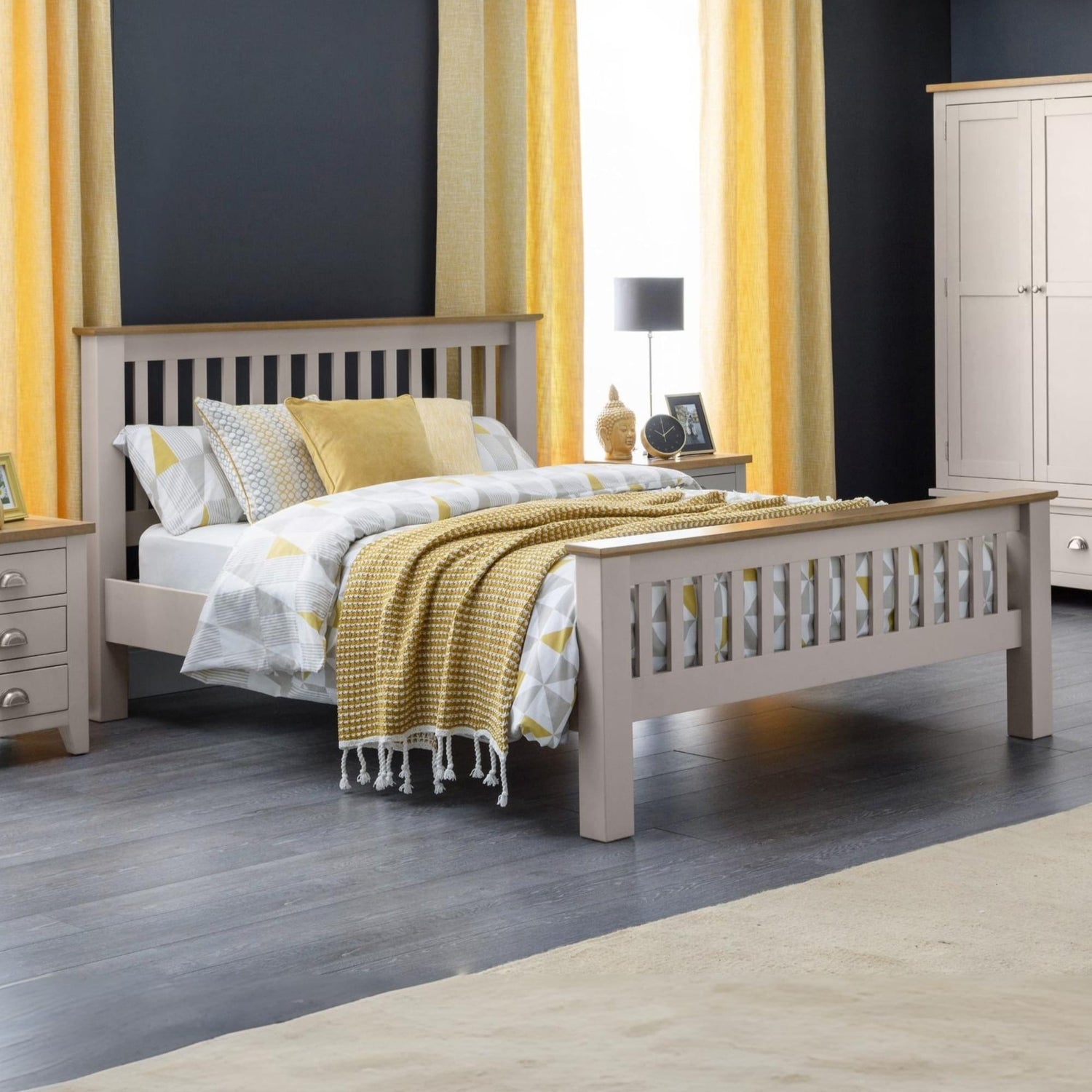 Bedroom with a gray bed frame, yellow bedding, and curtains.