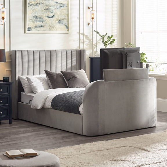 Gray upholstered bed in a bedroom setting with decor elements.