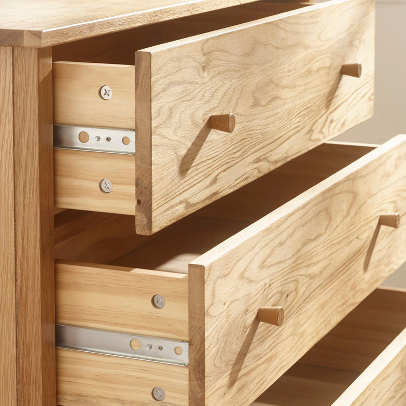 Wooden drawer unit with open drawers on a light background