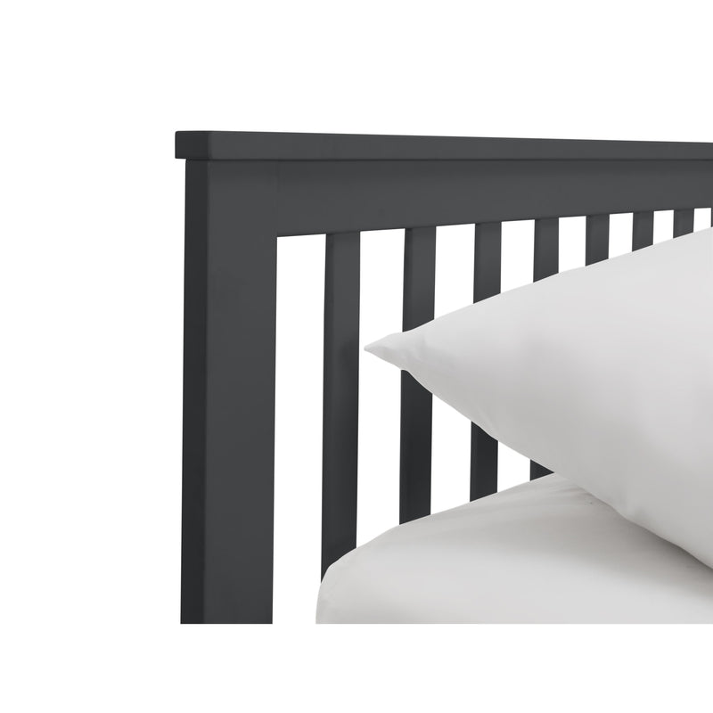 Black wooden headboard with white pillows on a white background