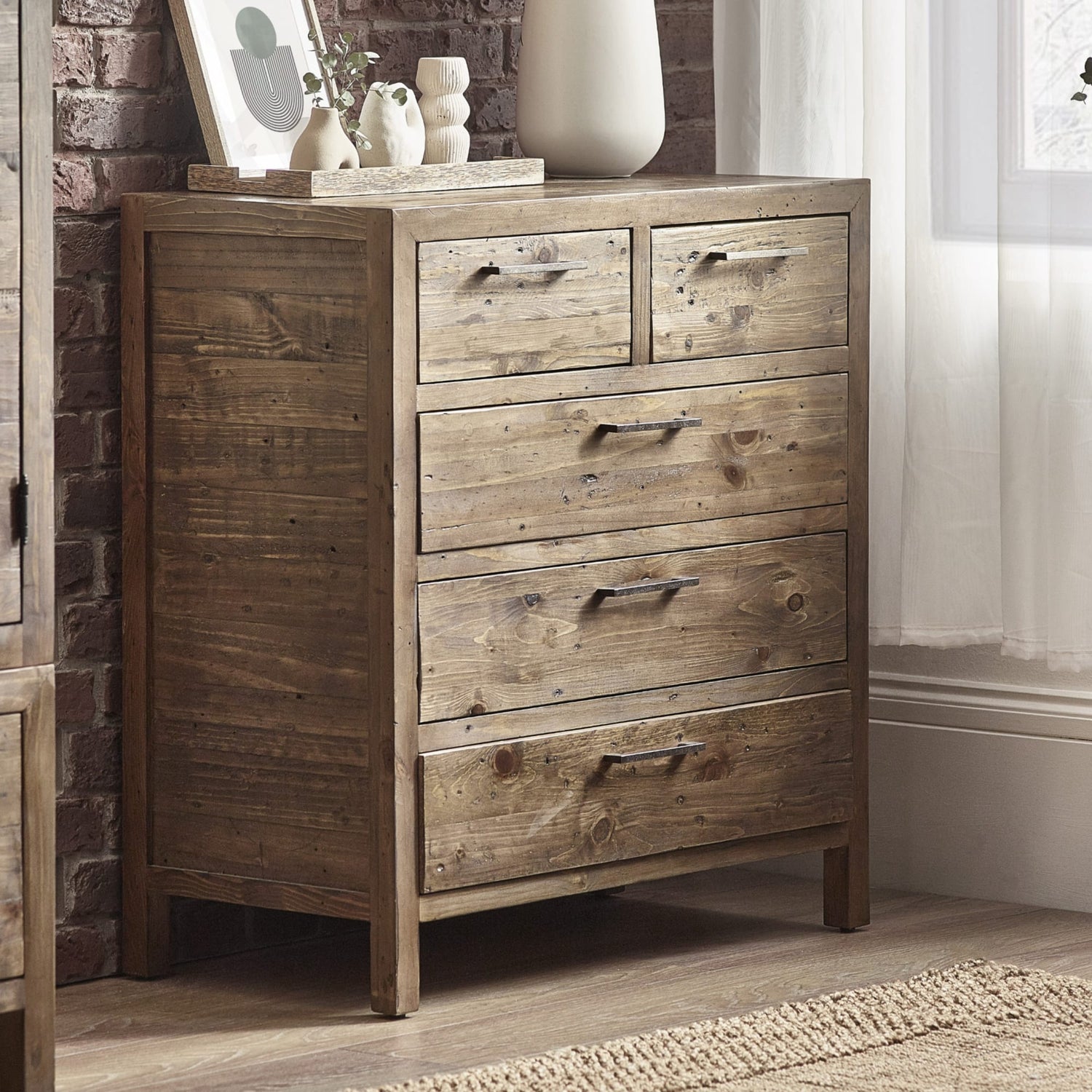 Wooden dresser with four drawers in a room setting.