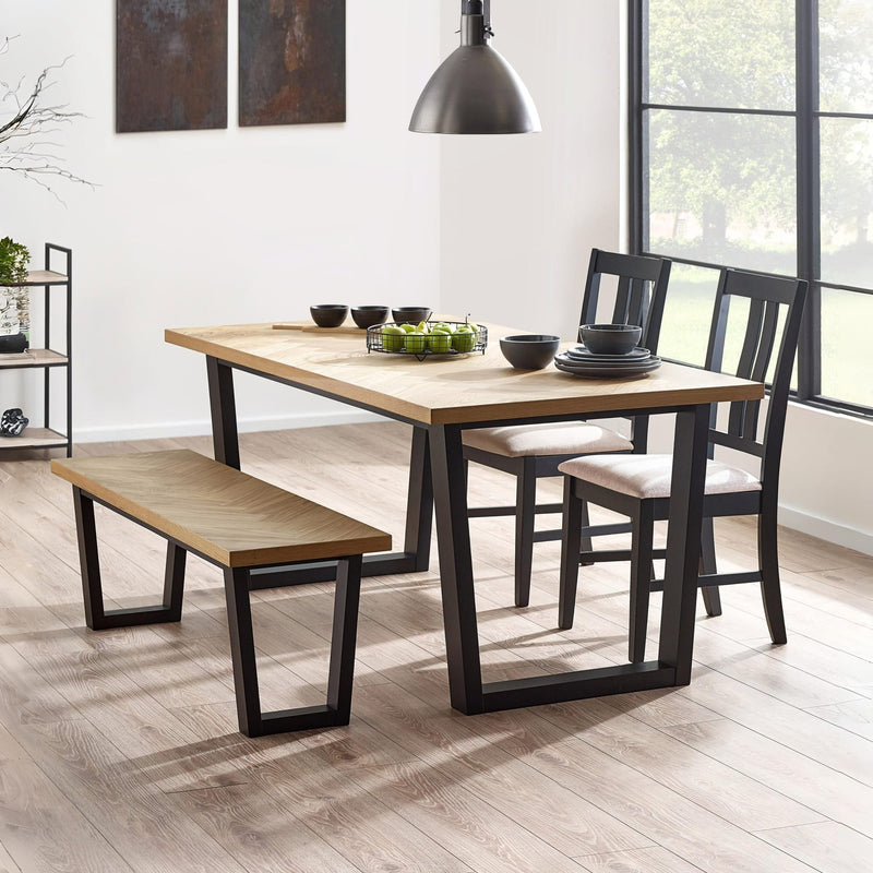 Dining room with a wooden table, chairs, and bench on a light wood floor.
