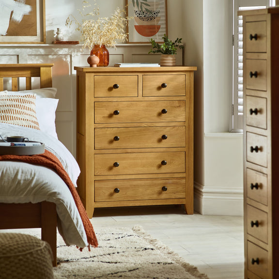 Wooden dresser in a bedroom with a bed and decor