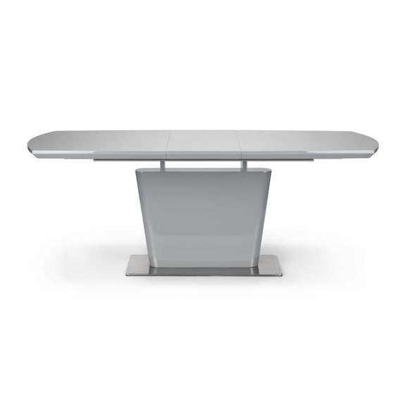 Modern dining table with a white surface and metallic base on a white background