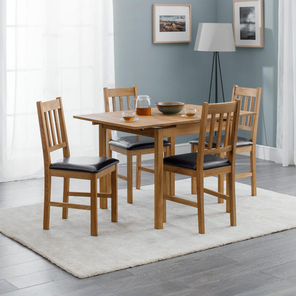 Dining room with wooden table and chairs against a gray wall.