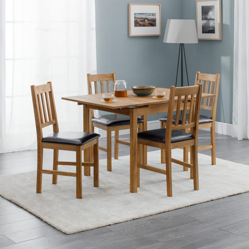 Dining room with wooden table and chairs against a gray wall.