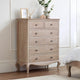 Wooden dresser with five drawers in a bedroom setting