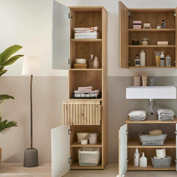 Bathroom with wooden cabinets and shelves containing toiletries and towels.