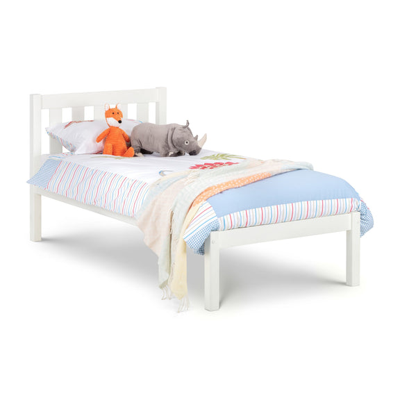 White children's bed with colorful bedding and stuffed animals on a white background