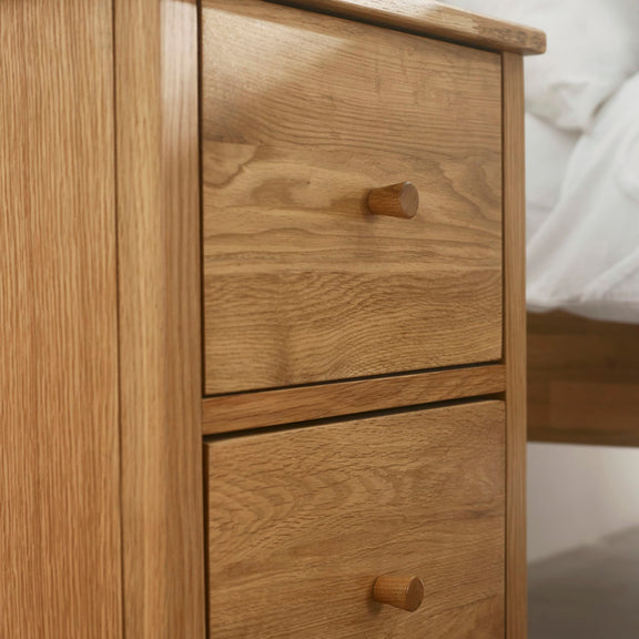 Wooden drawer with two knobs on a wooden cabinet.
