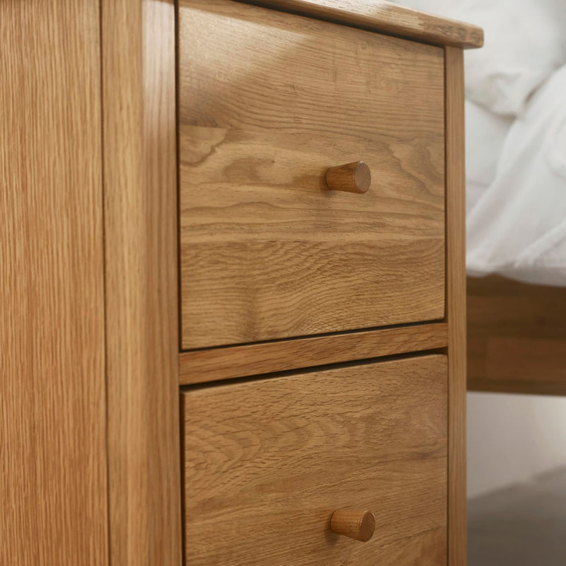 Wooden drawer with two knobs on a wooden cabinet.