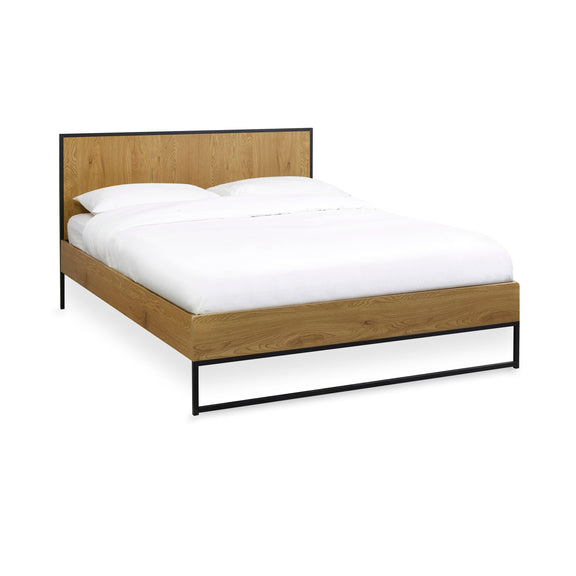 Wooden bed frame with white bedding on a white background