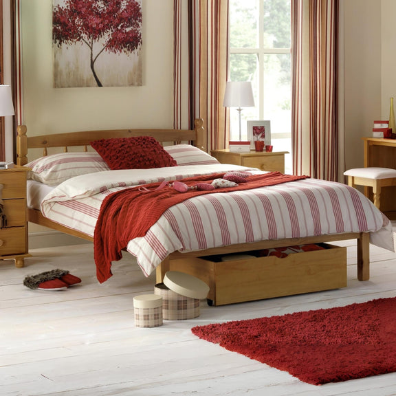 Bedroom with wooden bed, red and white striped bedding, and decorative items.