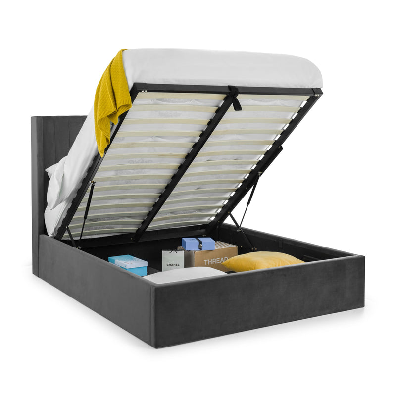 Black upholstered bed with open storage compartment on a white background