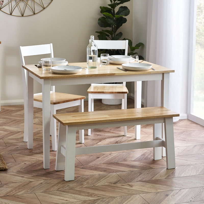 Dining room set with table, chairs, and bench on a wooden floor.