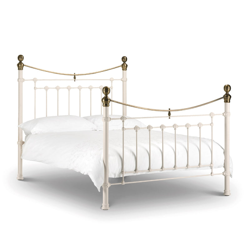 Vintage-style metal bed with brass accents on a white background