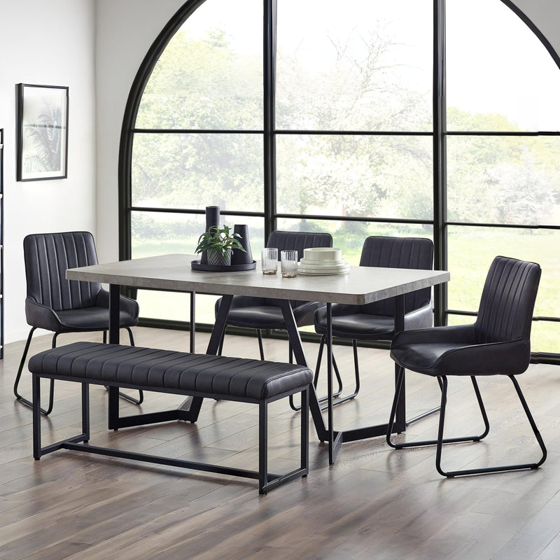 Dining room with a table and chairs in front of large windows.