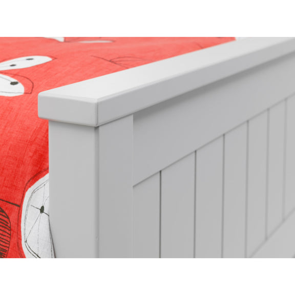 White bed frame with red bedding featuring cartoon characters.