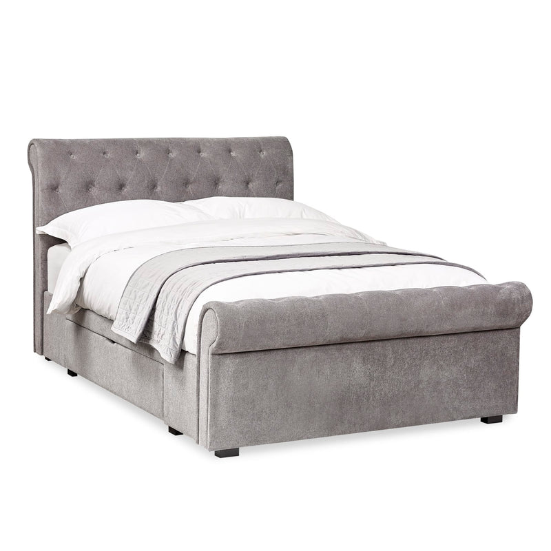 Gray upholstered bed with white bedding on a white background