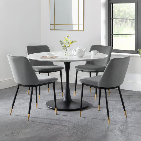 Dining room with a round table and gray chairs in a modern interior setting.