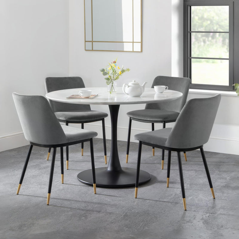 Dining room with a round table and gray chairs in a modern interior setting.