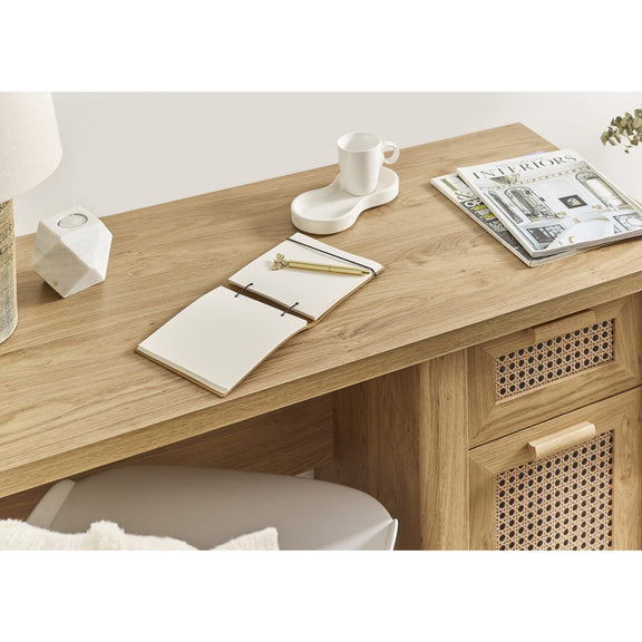 Wooden desk with a notebook, mug, and magazine on a light background