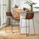 Two brown bar stools with black metal legs in a modern kitchen setting.