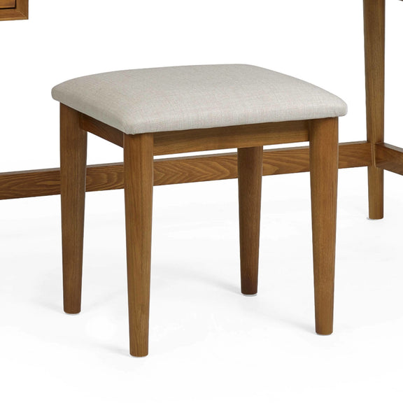 Wooden stool with a beige cushion on a white background