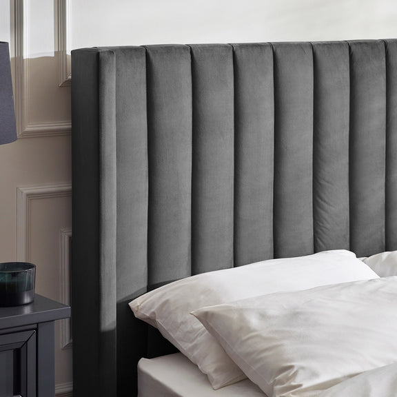 Gray upholstered headboard with white bedding in a bedroom setting