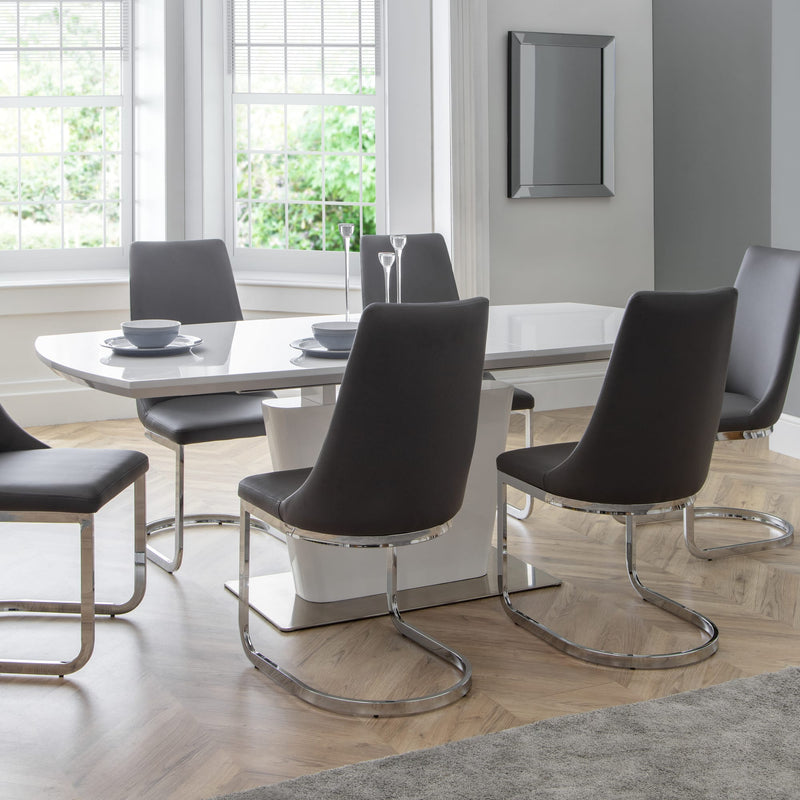 Modern dining room with a white dining table and black chairs.