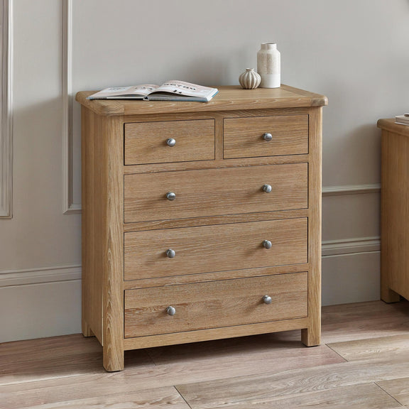 Wooden chest of drawers with four drawers in a room setting.