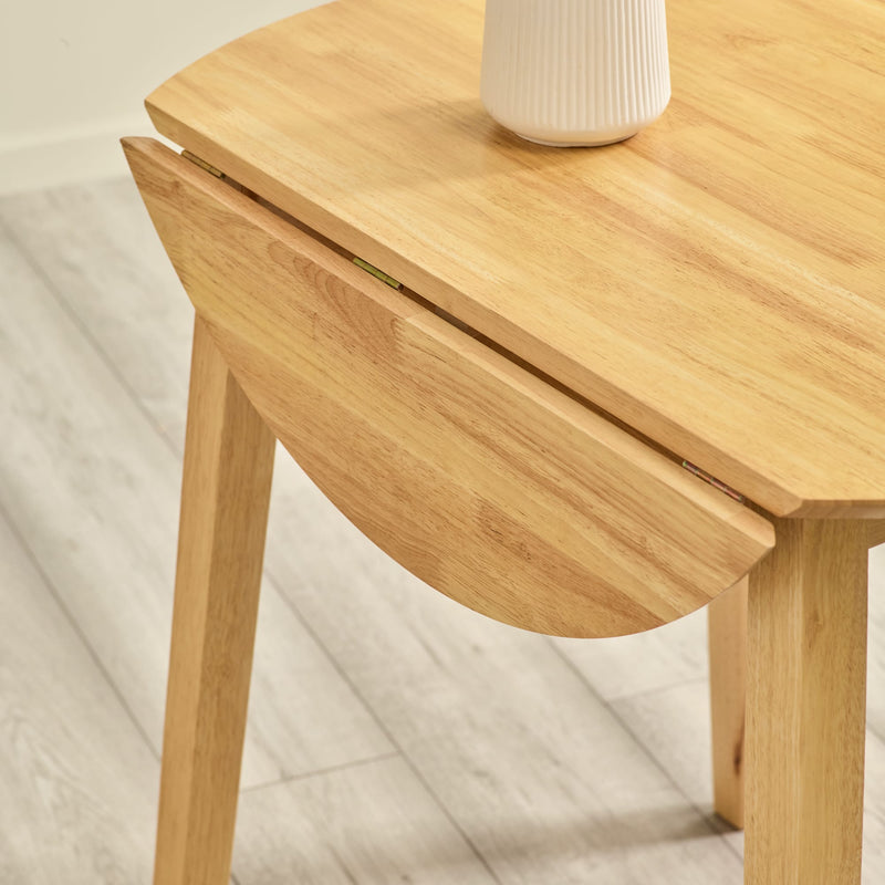 Wooden side table with a white vase on a light wooden floor