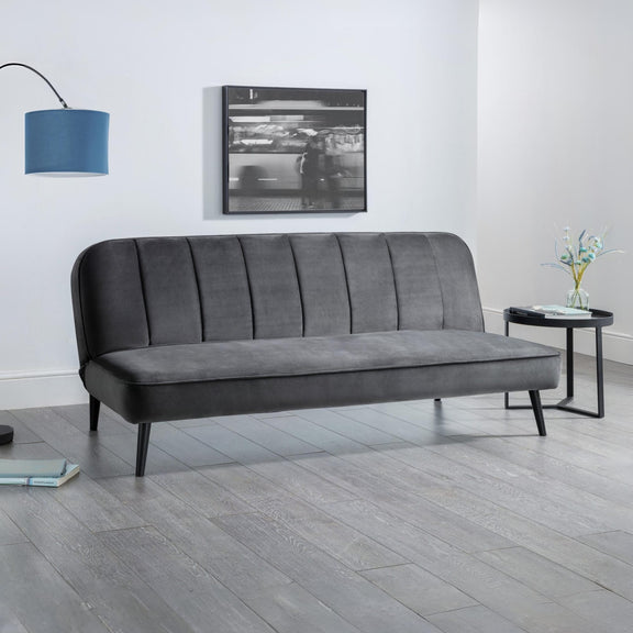 Gray sofa in a modern living room with a lamp and wall art.