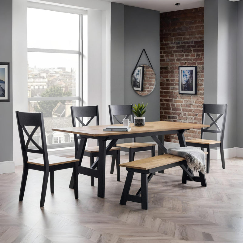 Dining room with wooden table and chairs against a brick wall.
