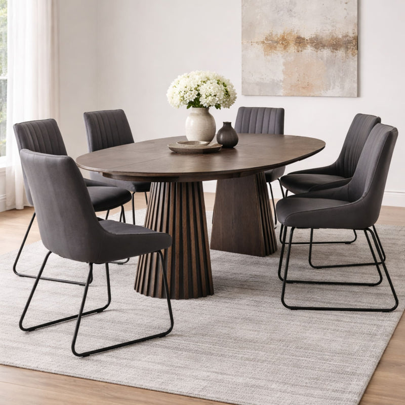 Dining room with a wooden table and gray chairs on a light rug.