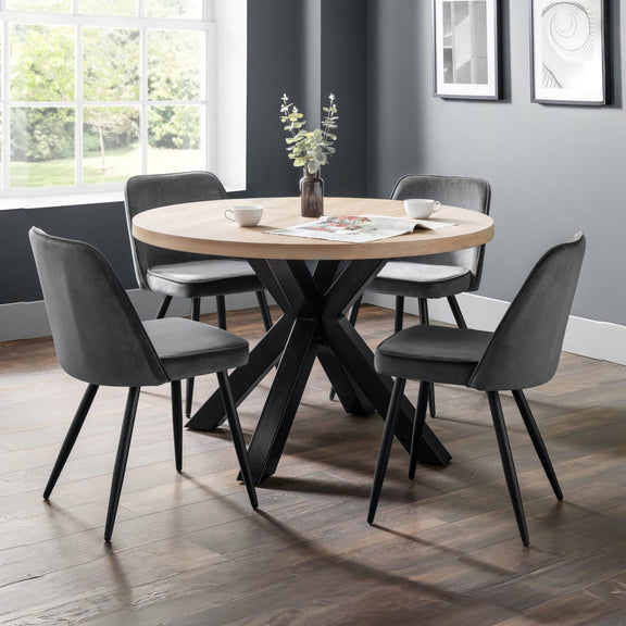 Dining room with round wooden table and gray chairs against a gray wall.