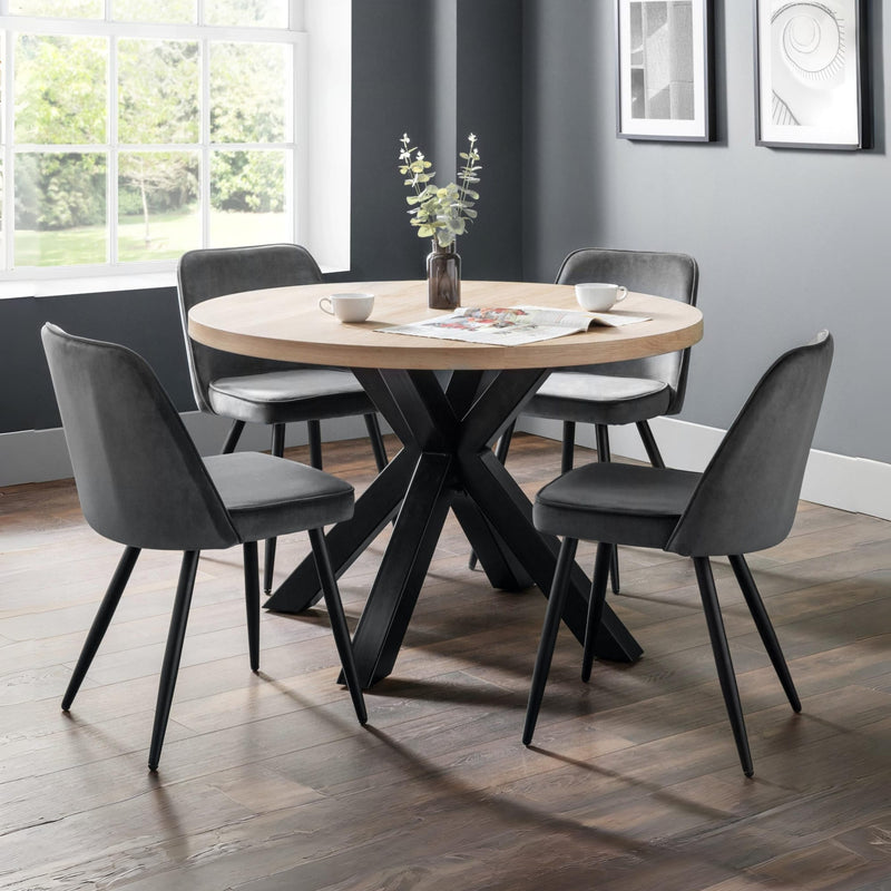 Dining room with round wooden table and gray chairs against a gray wall.