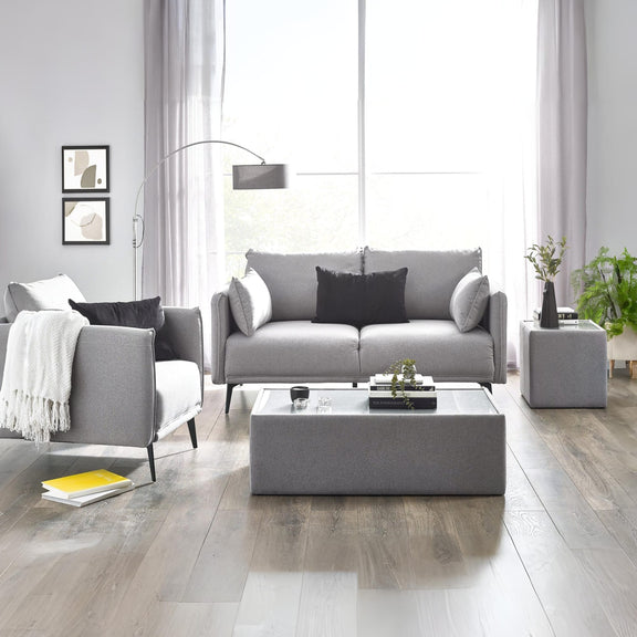 Modern living room with gray sofa, armchair, and coffee table.