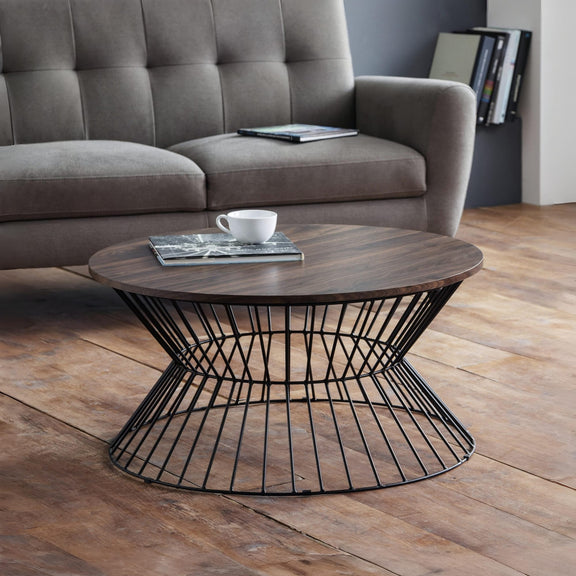 Round wooden coffee table with metal base in a living room setting