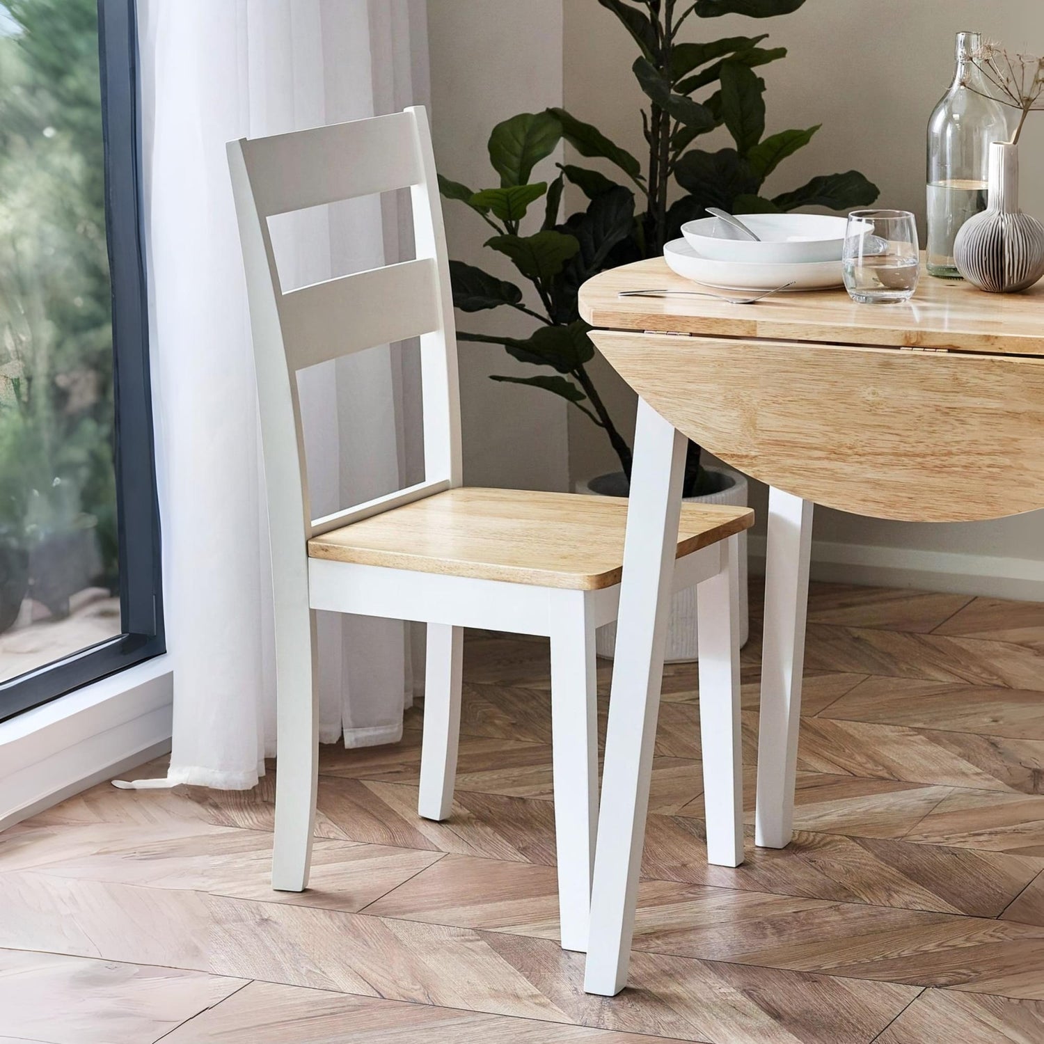 Wooden dining table with a chair in a room with a window and plants.
