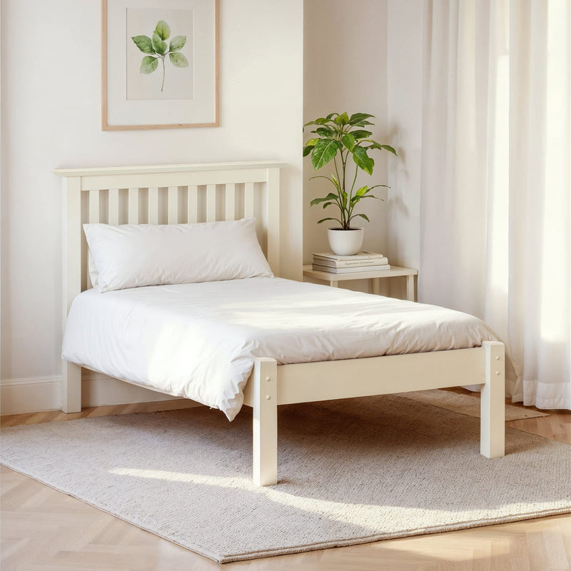 Beige wooden bed with white bedding in a bright bedroom setting.