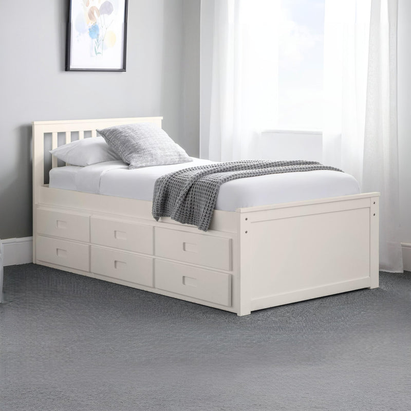 White bed with storage drawers in a bedroom setting
