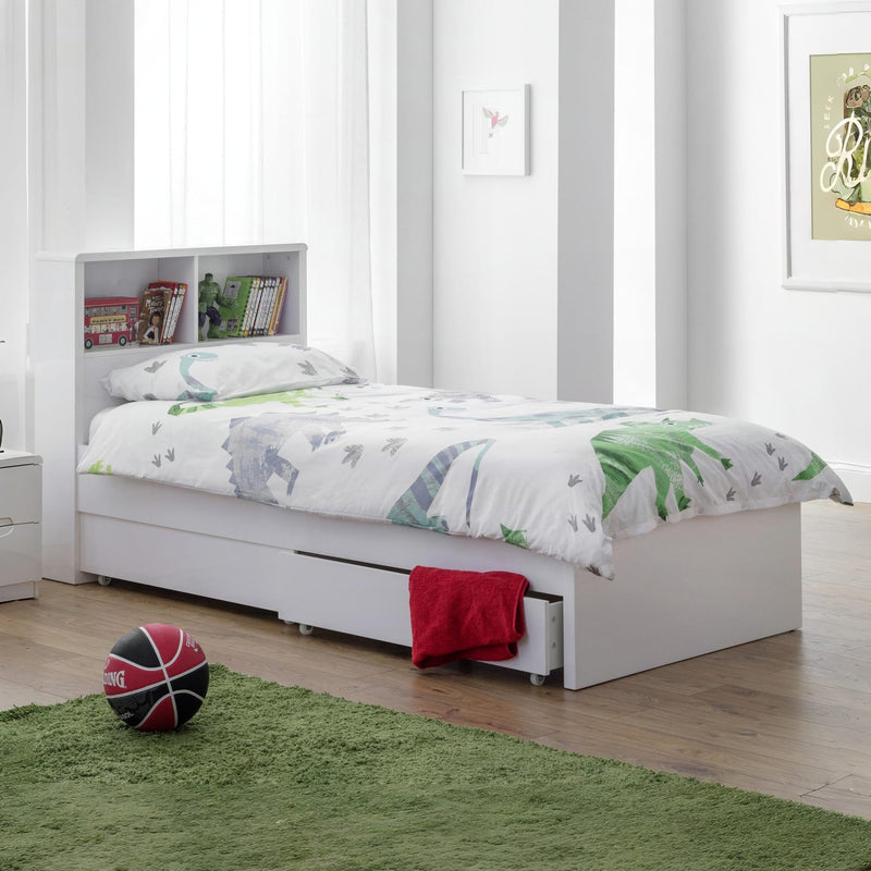 White bed with green bedding in a room with a basketball on the floor.