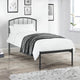 Bedroom with a black metal bed frame, white bedding, and decorative elements.