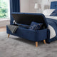 Navy blue storage bench in a room with a bed and window.