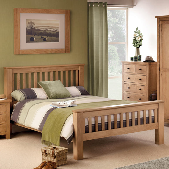 Wooden bed in a bedroom with green walls, curtains, and decor.