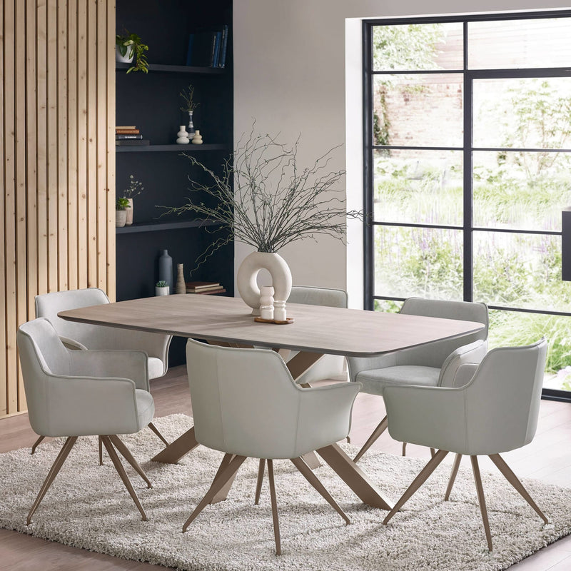 Dining room with a wooden table and white chairs near a large window.