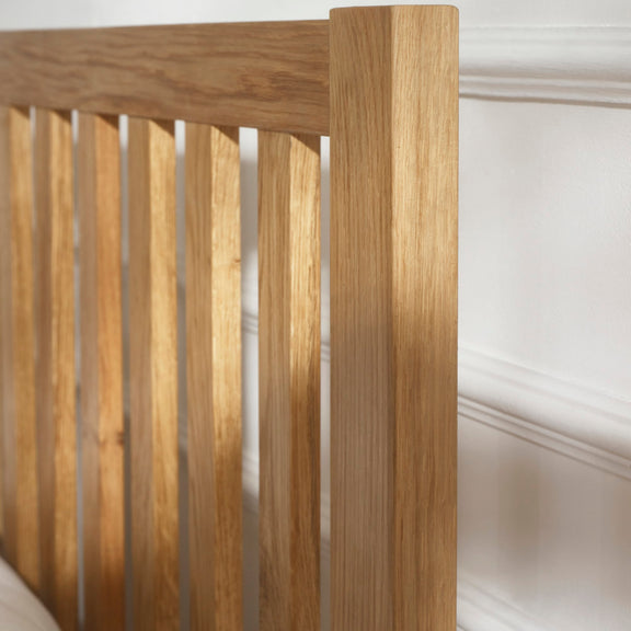 Wooden headboard with slatted design against a white wall
