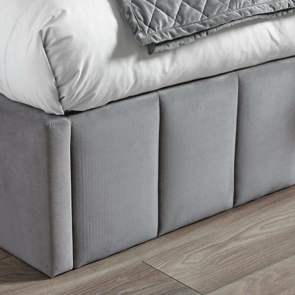 Gray upholstered bed frame with wooden flooring